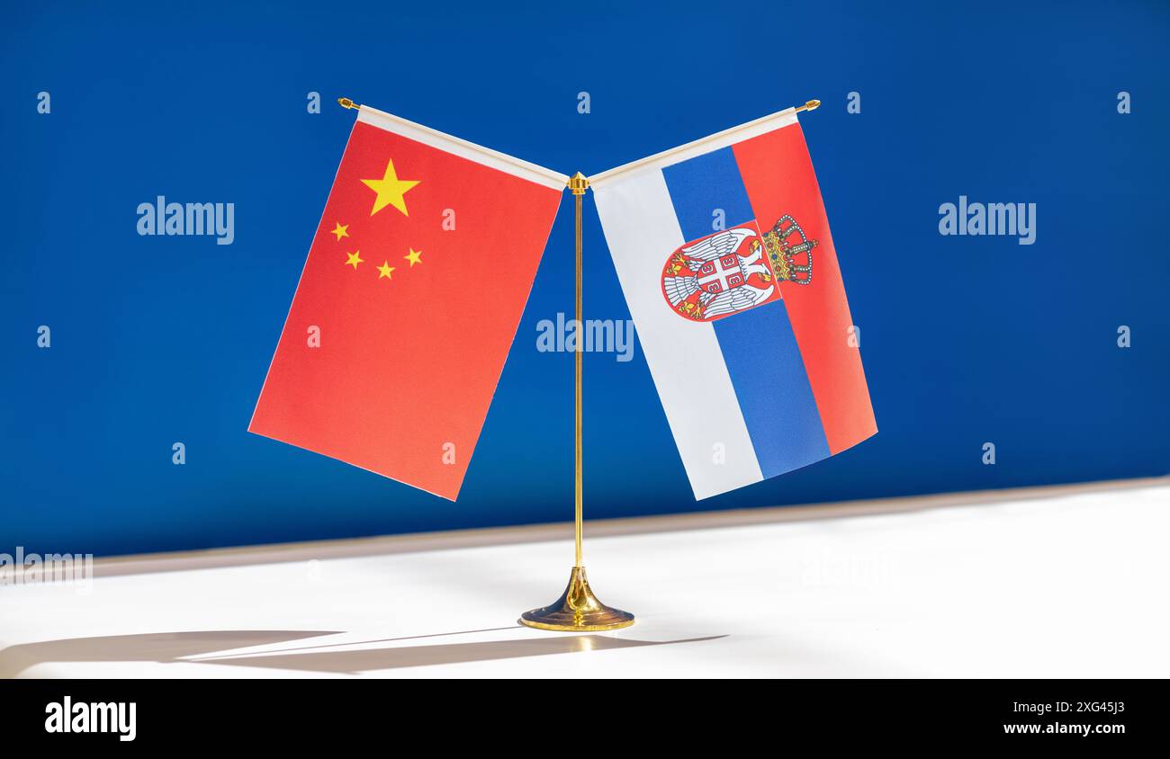 Bandiere nazionali cinesi e serbe su sfondo blu. Partenariato economico e politico tra i due paesi Foto Stock