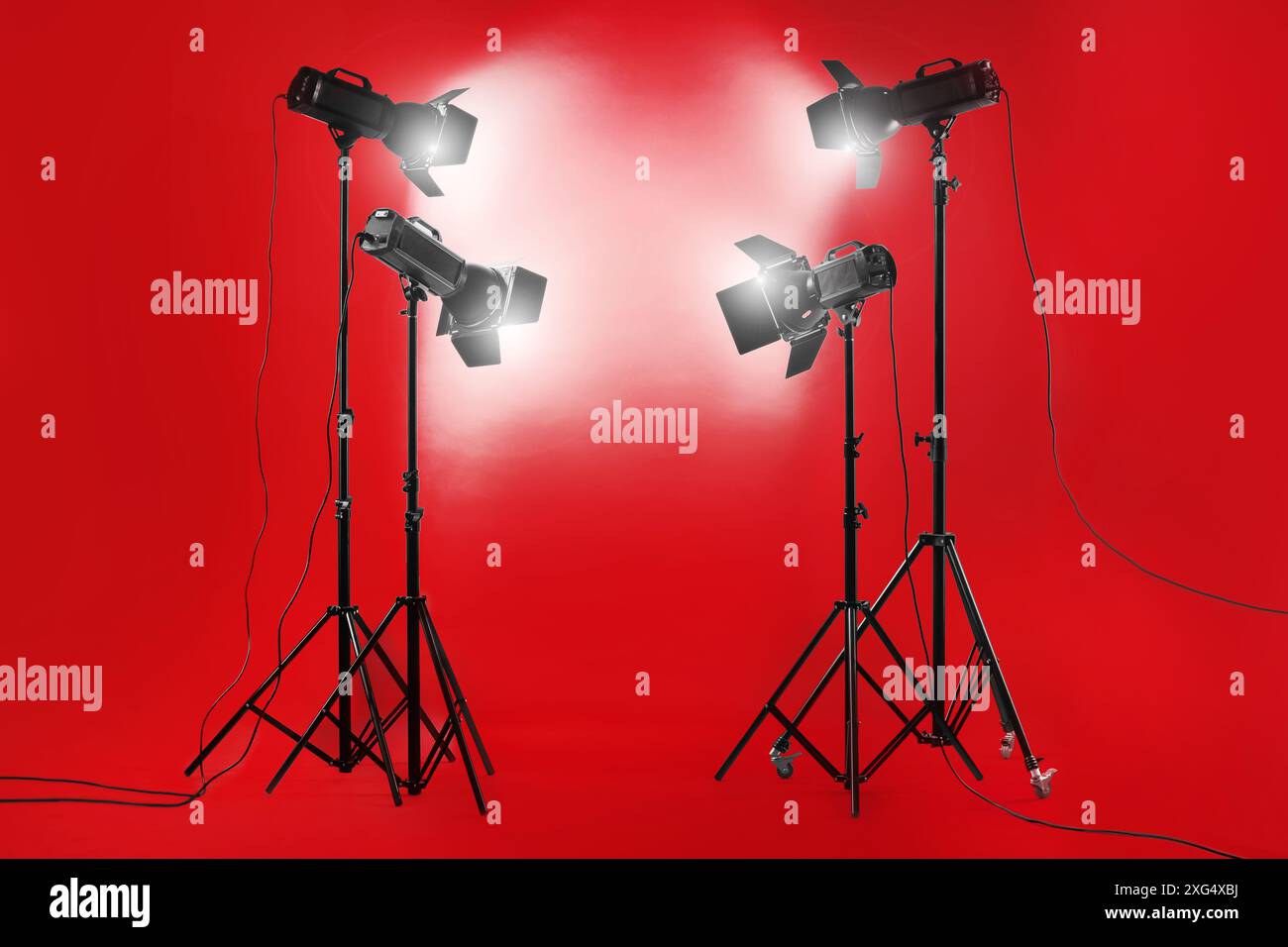 Sfondo fotografico rosso e apparecchiature di illuminazione professionali in studio Foto Stock