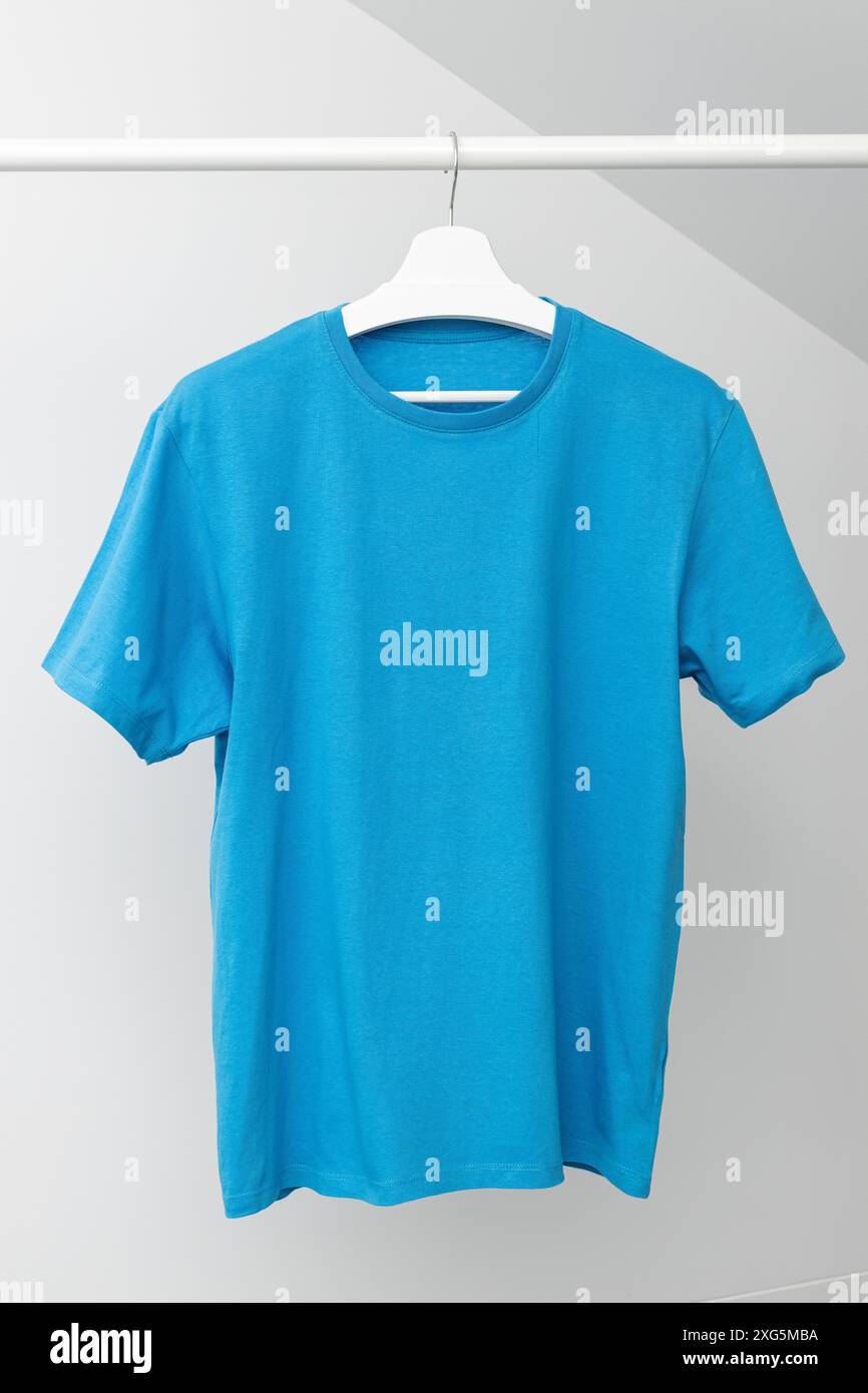 T-shirt appesa al portabiti. Colore blu collo rotondo. Modello, mock up Foto Stock