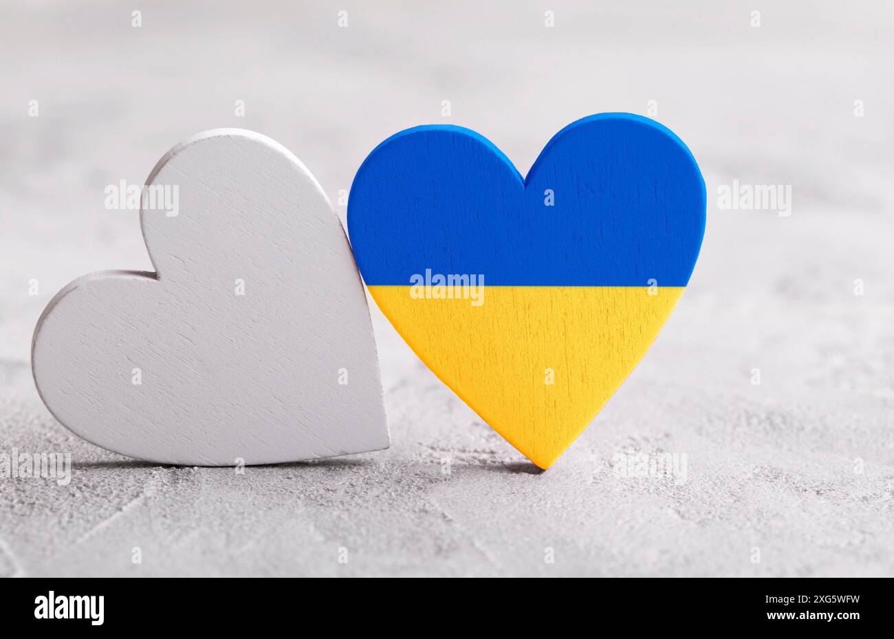 Cuore con colori della bandiera Ucraina sullo sfondo grigio in pietra. Ferma la guerra in Ucraina Foto Stock