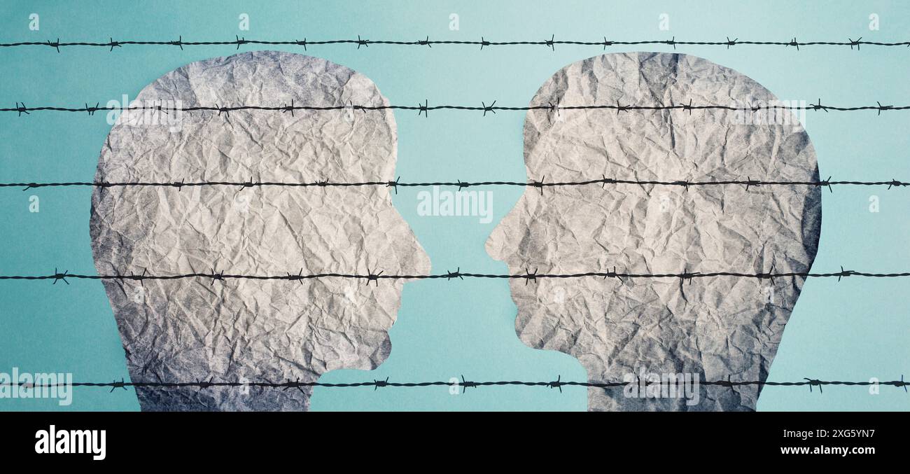 Due sagome di volti si guardano l'un l'altro dietro una recinzione spinato, campo profughi, prigionieri Foto Stock