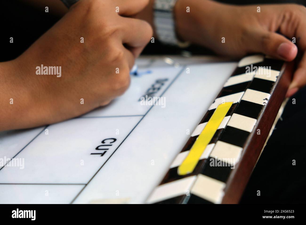 Lavagna per clapper e mani della troupe cinematografica. Concetto di produzione cinematografica. Foto Stock