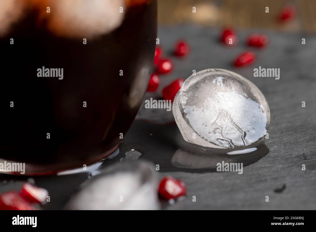 succo di melograno rosso naturale con ghiaccio, succo di semi di melograno freddo con pezzi di ghiaccio Foto Stock