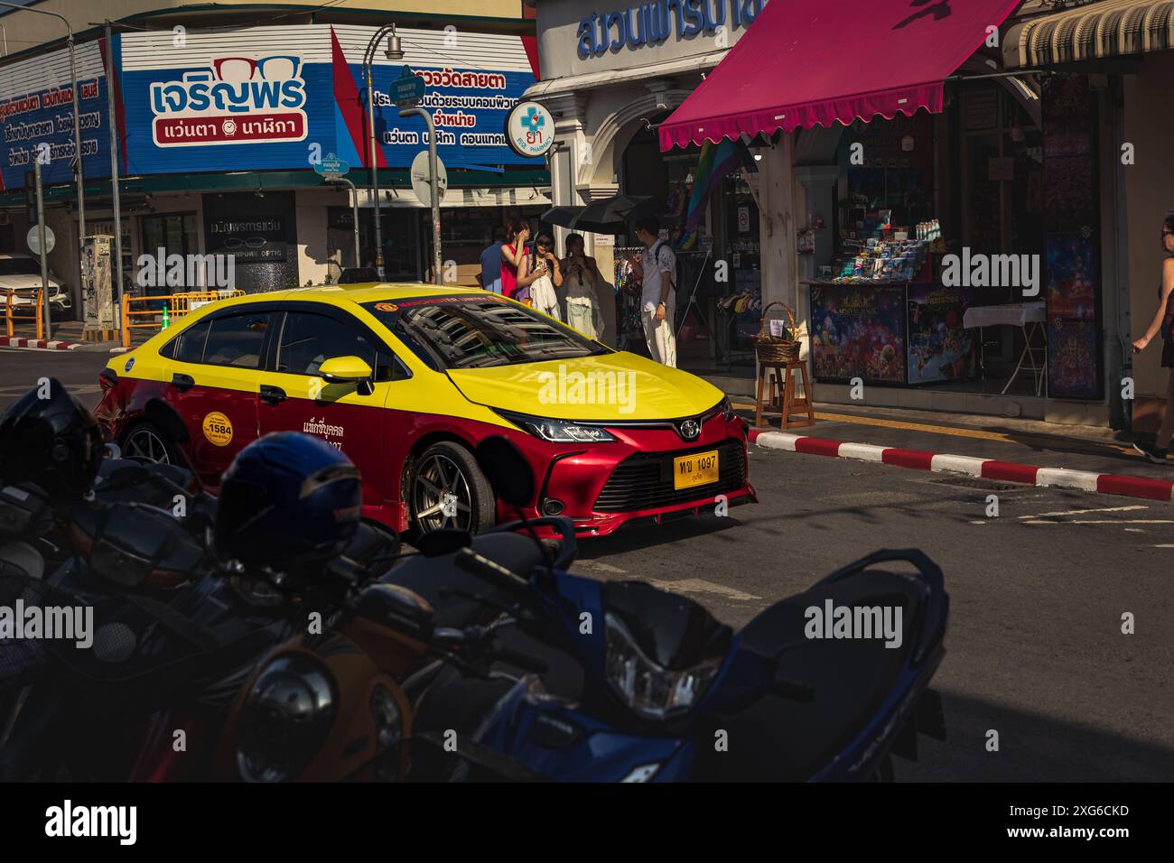 Thailandia. Taxi locale di Phuket di colore giallo e rosso nella città vecchia con sino-portoghese. Strada trafficata. Negozi e ristoranti nella città vecchia. Attrazione turistica Foto Stock