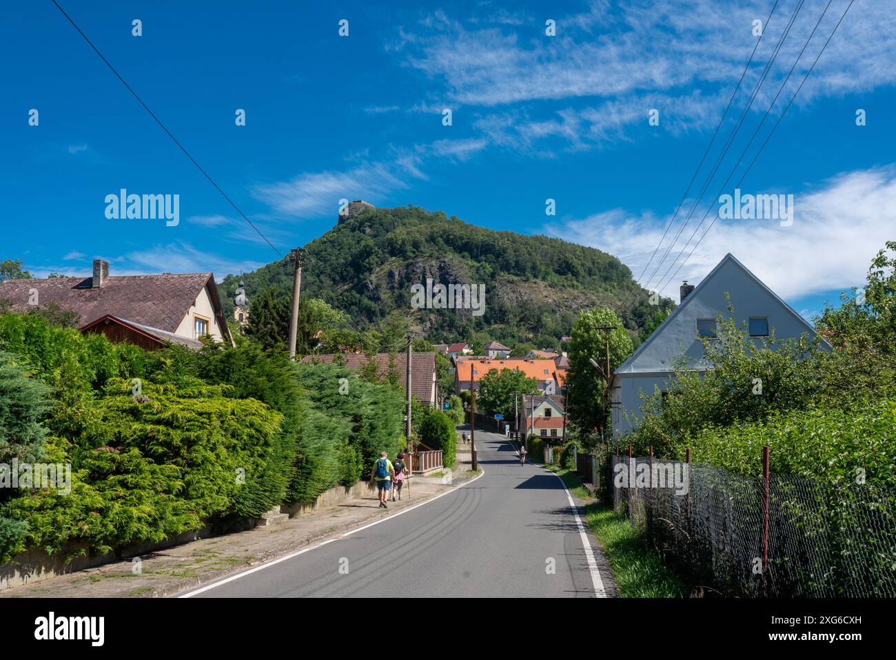 Collina con il castello di Kalich costruito da Jan Žižka e il villaggio di Třebušín negli altopiani della Boemia centrale, in Cechia. Alcuni turisti si trovano sulla strada. Foto Stock