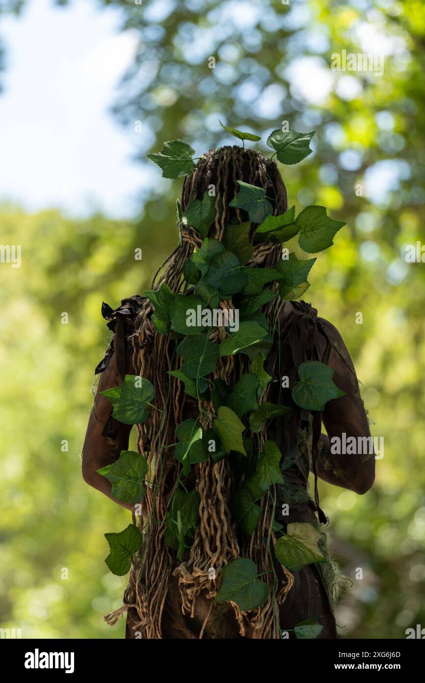 La Statua vivente di un albero con foglie. Mescolato con la natura, sfondo sfocato. Foto Stock