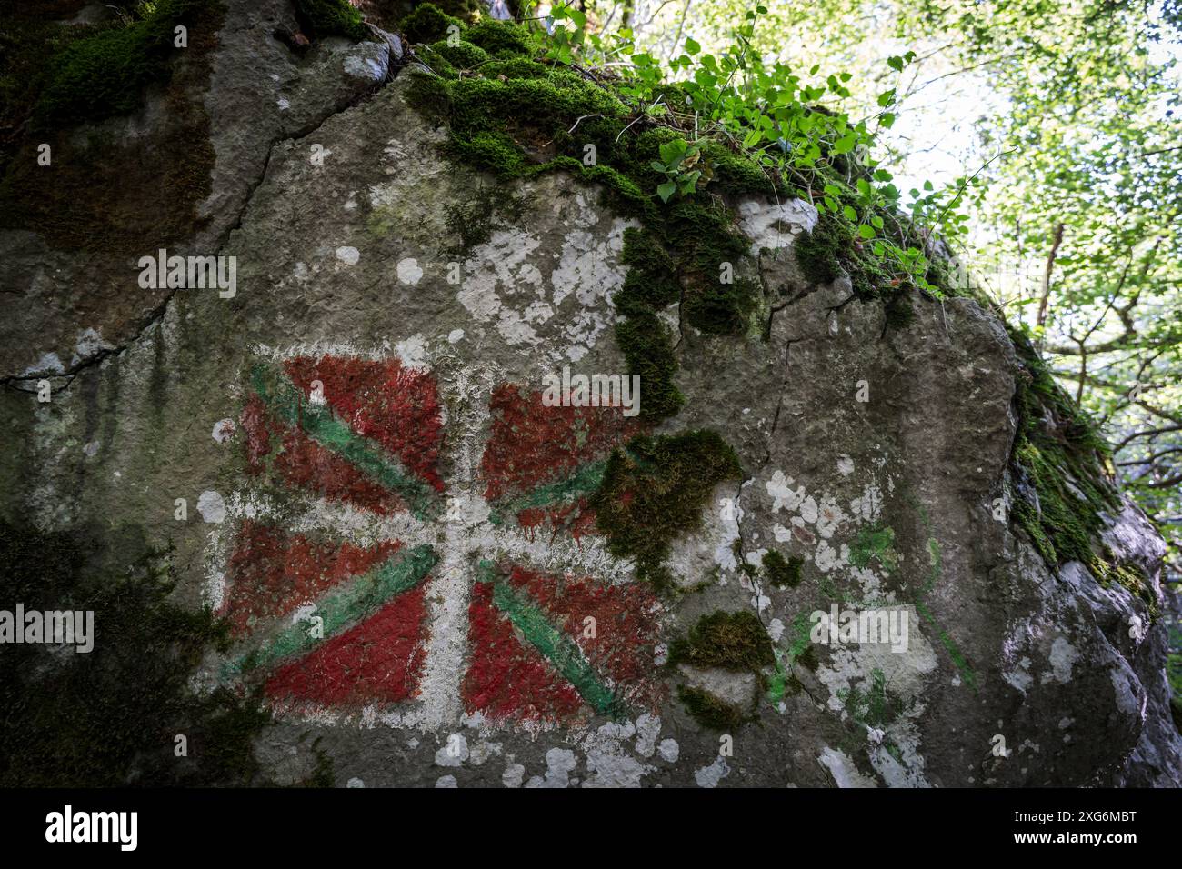 Bandiera basca dipinta sulla roccia, ikurrina, sentiero GR 20 - percorso circolare per Aralar, parco naturale Aralar, Guipuzcoa-Navarra, Spagna. Foto Stock