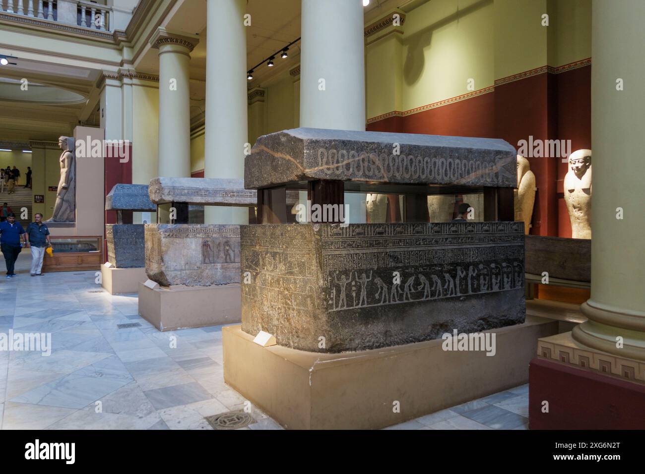Vista interna del Museo Egizio del Cairo, in Egitto, con antichi sarcofagi egizi e statue esposte in una sala con colonne classiche Foto Stock