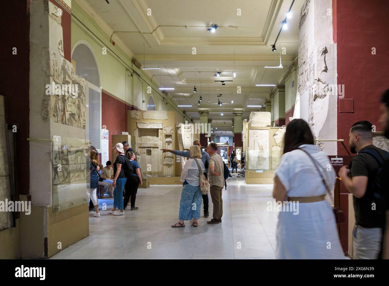 I visitatori osservano le antiche sculture in pietra e i manufatti al Museo Egizio del Cairo, in Egitto Foto Stock