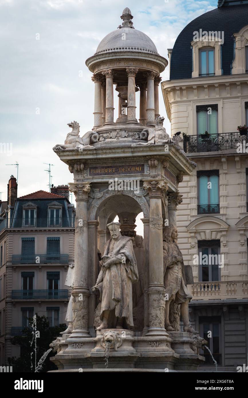 Esplora l'affascinante fontana artesiana di Lione adornata con famose sculture, tra cui un maestoso leone, che offre uno sguardo sul ricco cultur della città Foto Stock