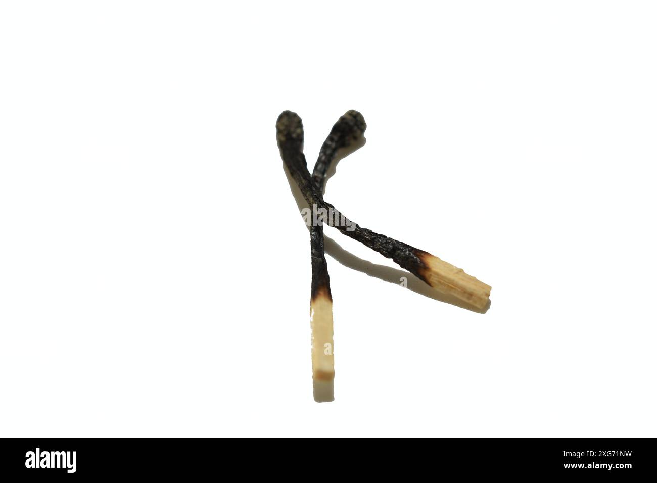 Due fiammiferi di legno bruciati giacciono su sfondo bianco. Foto Stock