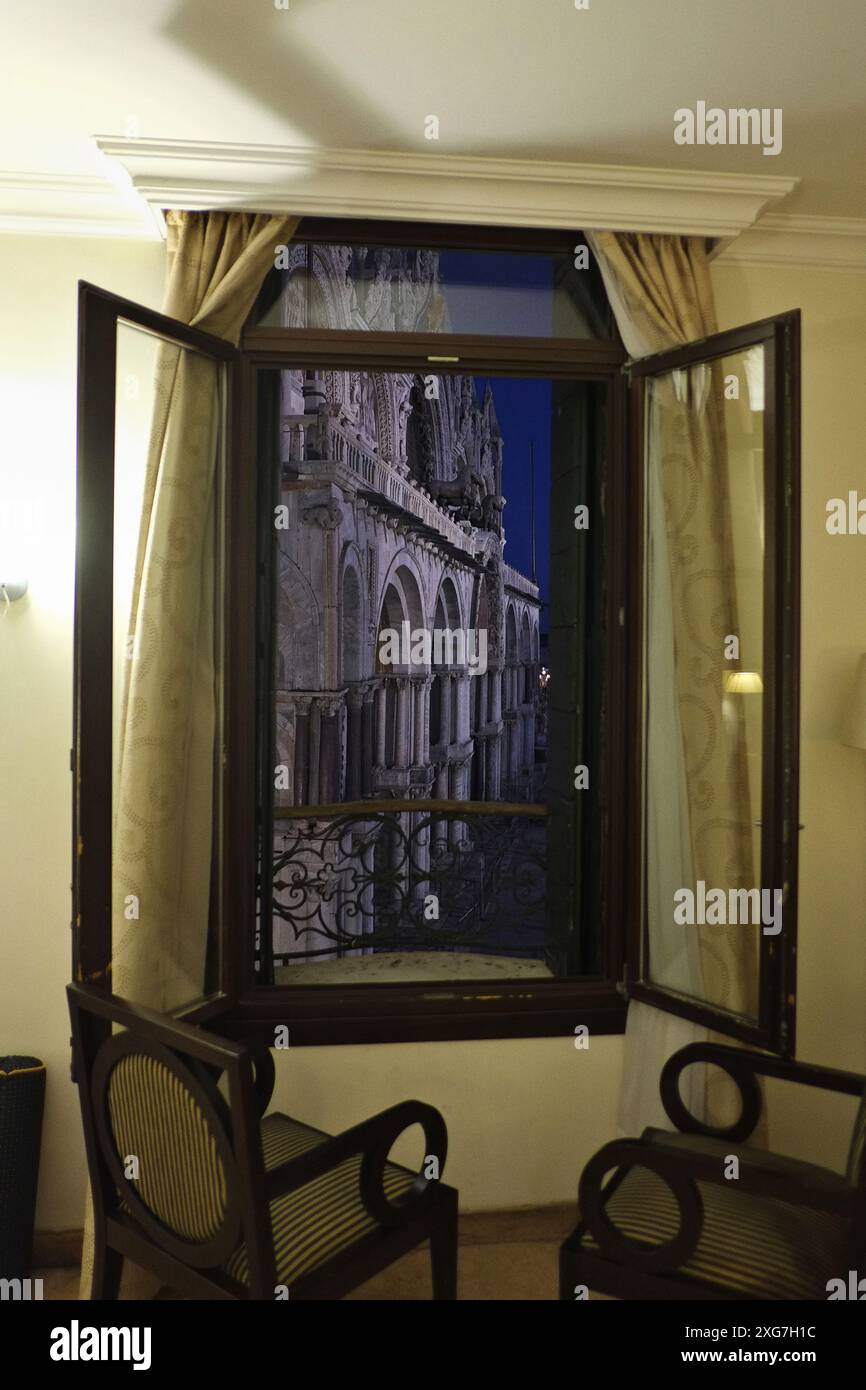 Un'ottima camera d'albergo con vista sulla Basilica di San Marco, Venezia, vista dalle finestre aperte che si affacciano su Piazza San Marco, i quattro cavalli, di notte Foto Stock