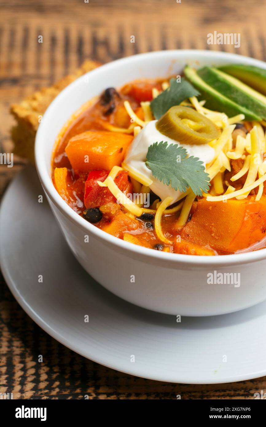 Peperoncino di zucca invernale vegano, servito con pane di mais Foto Stock