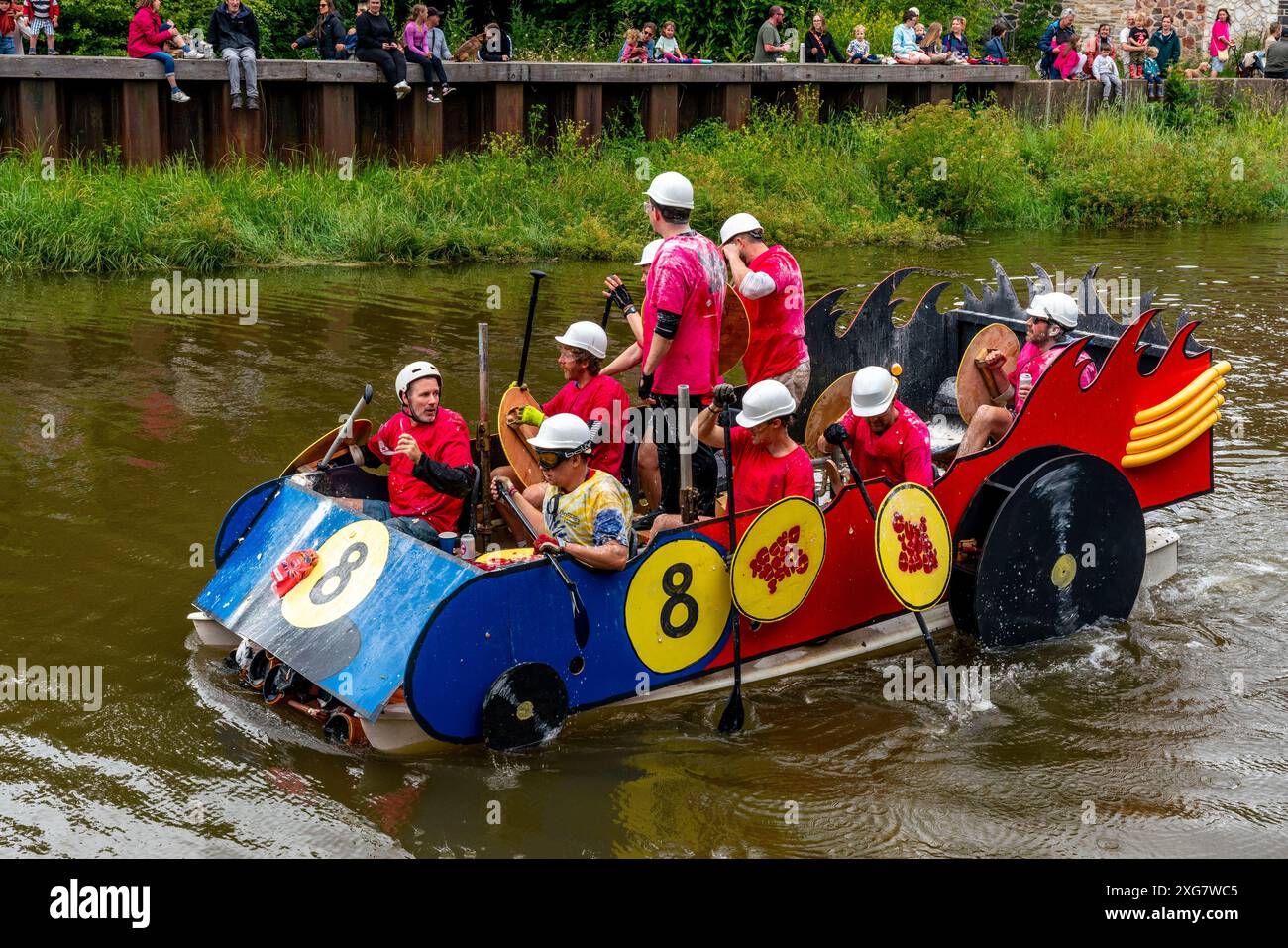 Lewes, Regno Unito. 7 luglio 2024. La gente del posto, in zattere fatte in casa, partecipa alla Lewes Raft Race sul fiume Ouse da Lewes a Newhaven. La Raft Race è un evento annuale organizzato da Lewes Round Table in aiuto di enti di beneficenza locali. Tradizionalmente, gli spettatori si allineano sulla riva del fiume e gettano uova e farina alle zattere con la gente sulle zattere che si protegge con scudi fatti in casa. Credito: Grant Rooney/Alamy Live News Foto Stock