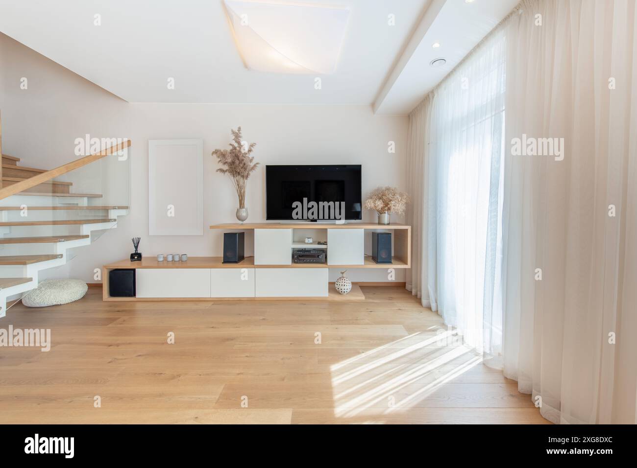Interno moderno del soggiorno della casa. Lussuoso ed elegante appartamento moderno. Design scandinavo. Schermo TV, luce solare, finestre e tende. Grandangolo Foto Stock