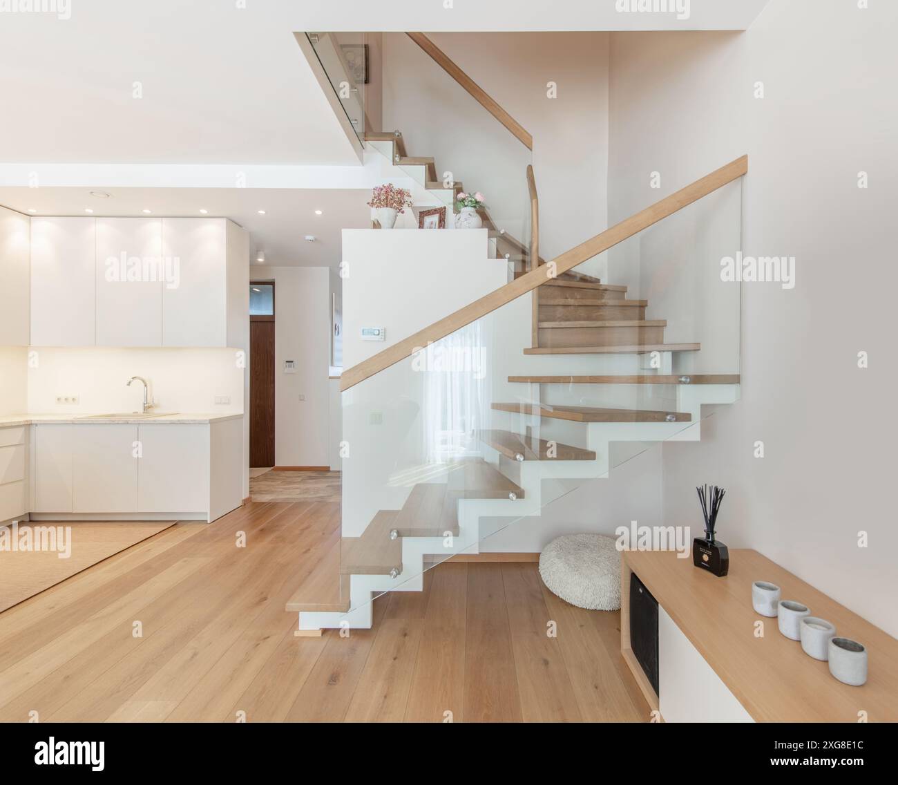 Cucina e interni del soggiorno in una nuova casa di lusso con pianta open space. Dispone di lavandino, pavimenti in legno duro e scale che portano al secondo piano. Ang. Larga Foto Stock
