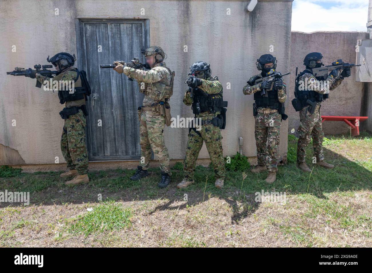 Un operatore della Naval Special Warfare (NSW) della costa occidentale esegue un addestramento di guerra urbana con i marinai della Japanese Maritime Self-Defense Force Special Boarding Unit e della Indian Marine Commando Force (MARCOS) durante l'esercitazione Rim of the Pacific (RIMPAC) 2024, 1 luglio. Ventinove nazioni, 40 navi di superficie, tre sottomarini, 14 forze terrestri nazionali, più di 150 aerei e 25.000 personale partecipano al RIMPAC nelle e intorno alle isole Hawaii, dal giugno 27 al agosto 1. Il RIMPAC, la più grande esercitazione marittima internazionale al mondo, offre un'opportunità di formazione unica, promuovendo e promuovendo la sus Foto Stock