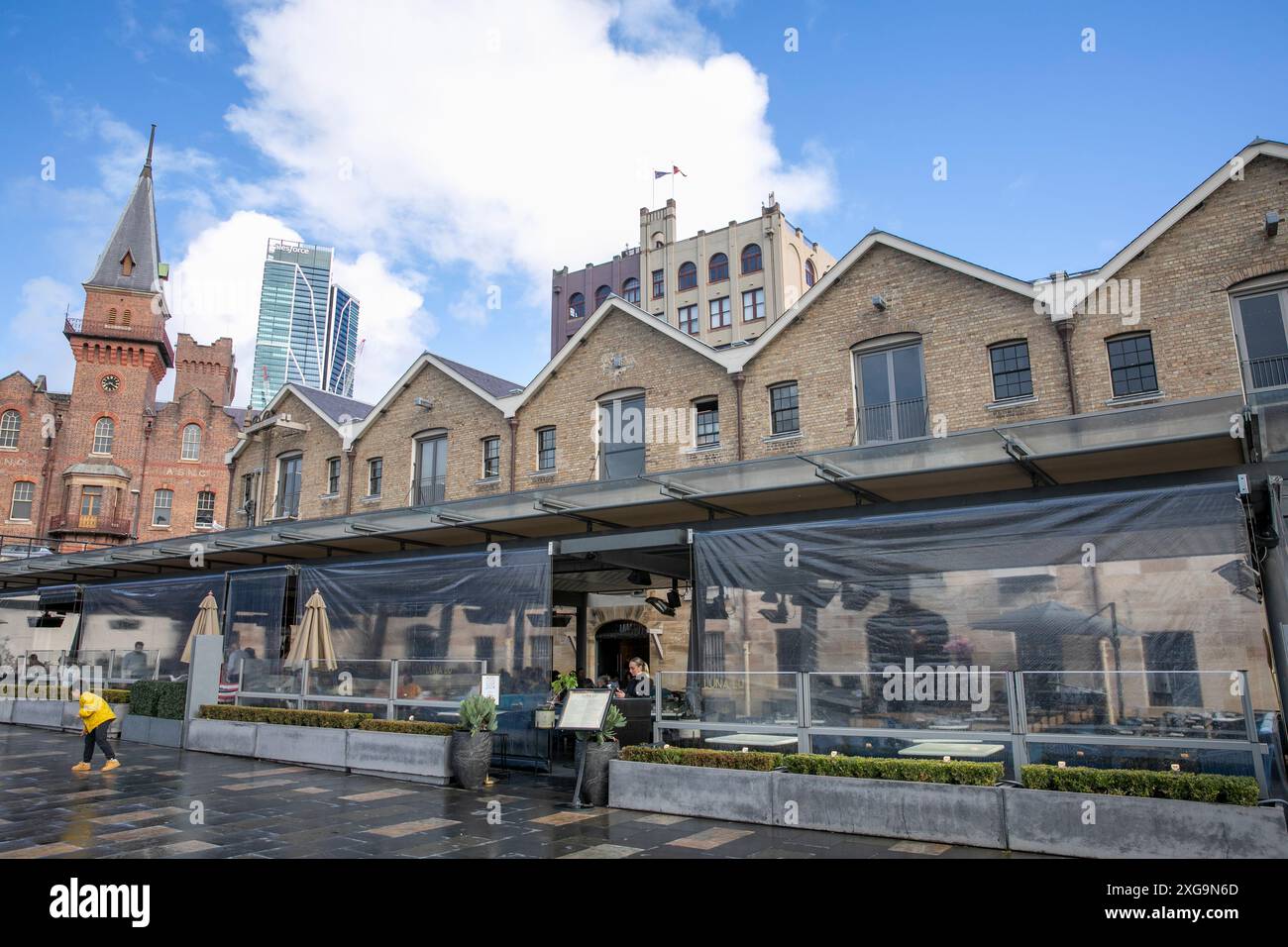 L'area di Sydney The Rocks della città con architettura coloniale nei negozi Campbells con il moderno grattacielo Salesforce, NSW, Australia Foto Stock