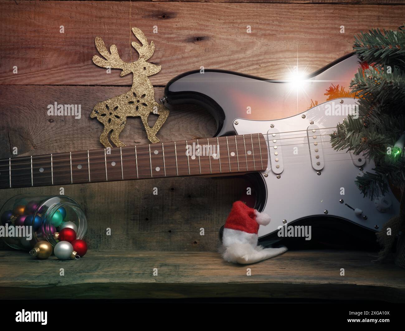 Vecchia chitarra d'epoca usata con luci di Natale su un pavimento in legno, concetto di musica di Natale Foto Stock