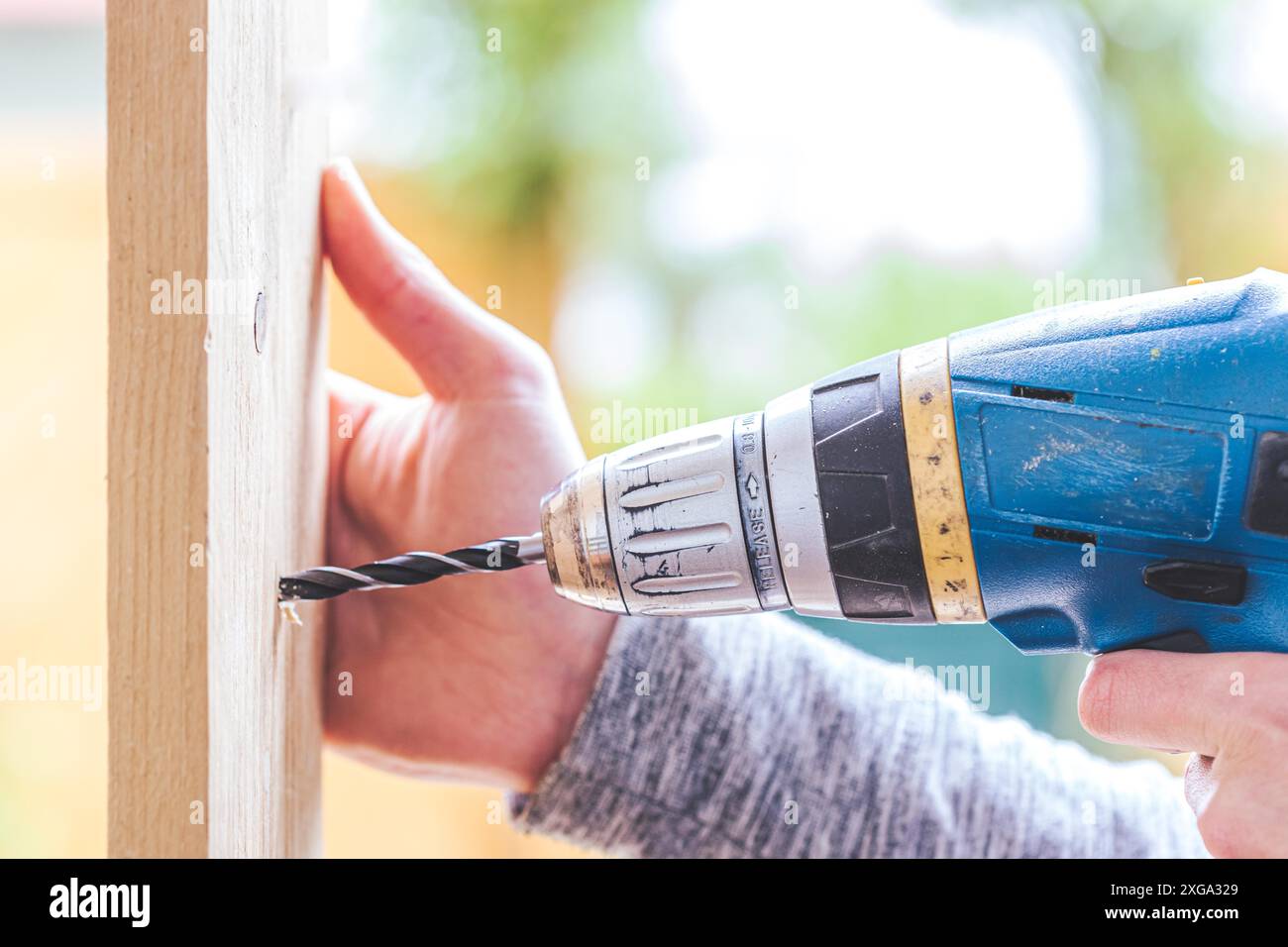 Fallo voi il handyman domestico sta usando un trapano per foratura del legno Foto Stock