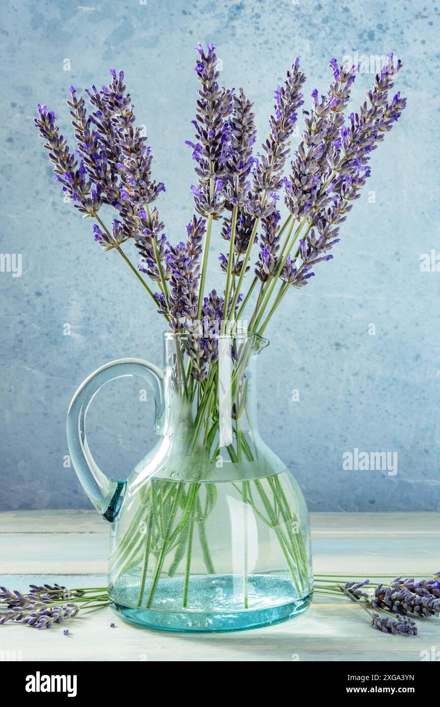 Bouquet di lavanda in bottiglia di vetro d'epoca, una nostalgica vita morta per un biglietto d'auguri Foto Stock