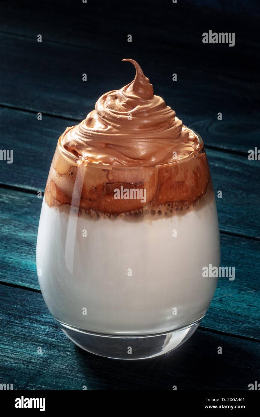 Caffè freddo Dalgona. Bevanda coreana con caffè istantaneo e crema, su sfondo scuro Foto Stock