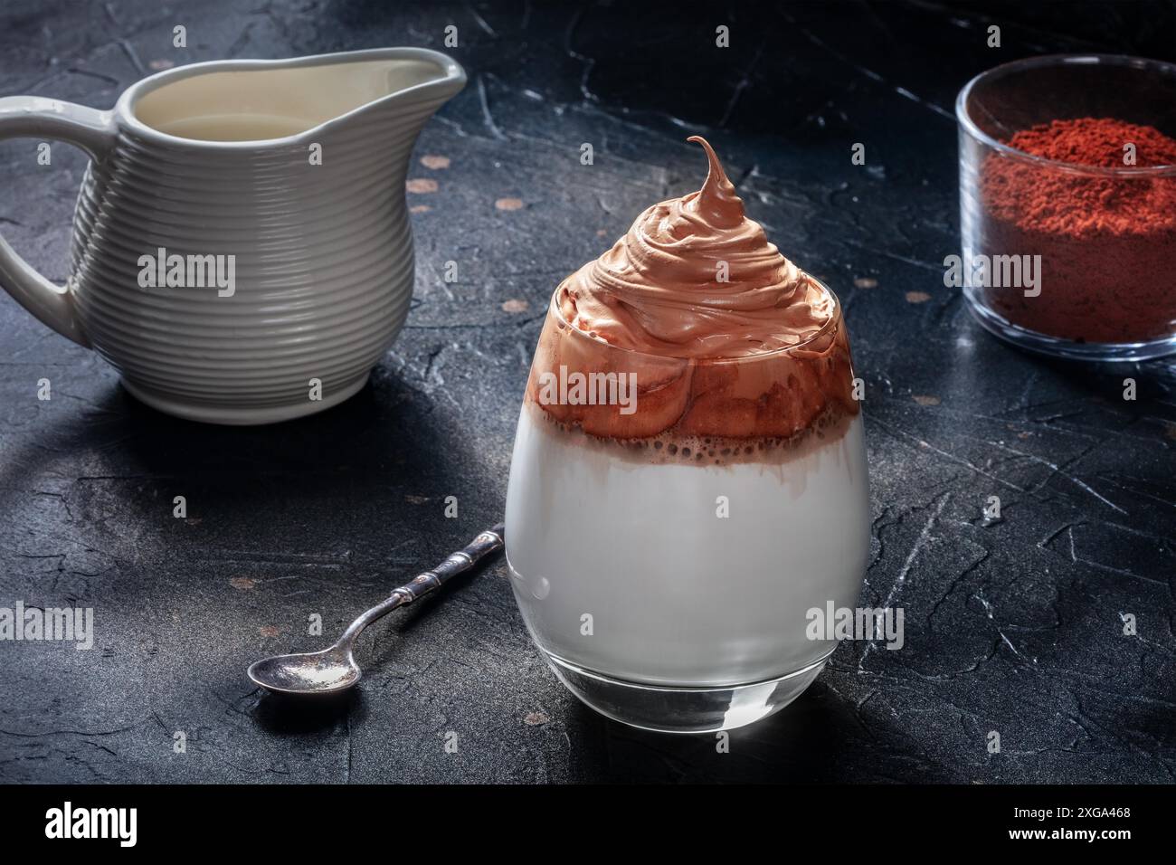 Ricetta del caffè freddo Dalgona con ingredienti su sfondo nero. Bevanda coreana dolce di caffè istantaneo e panna con zucchero Foto Stock