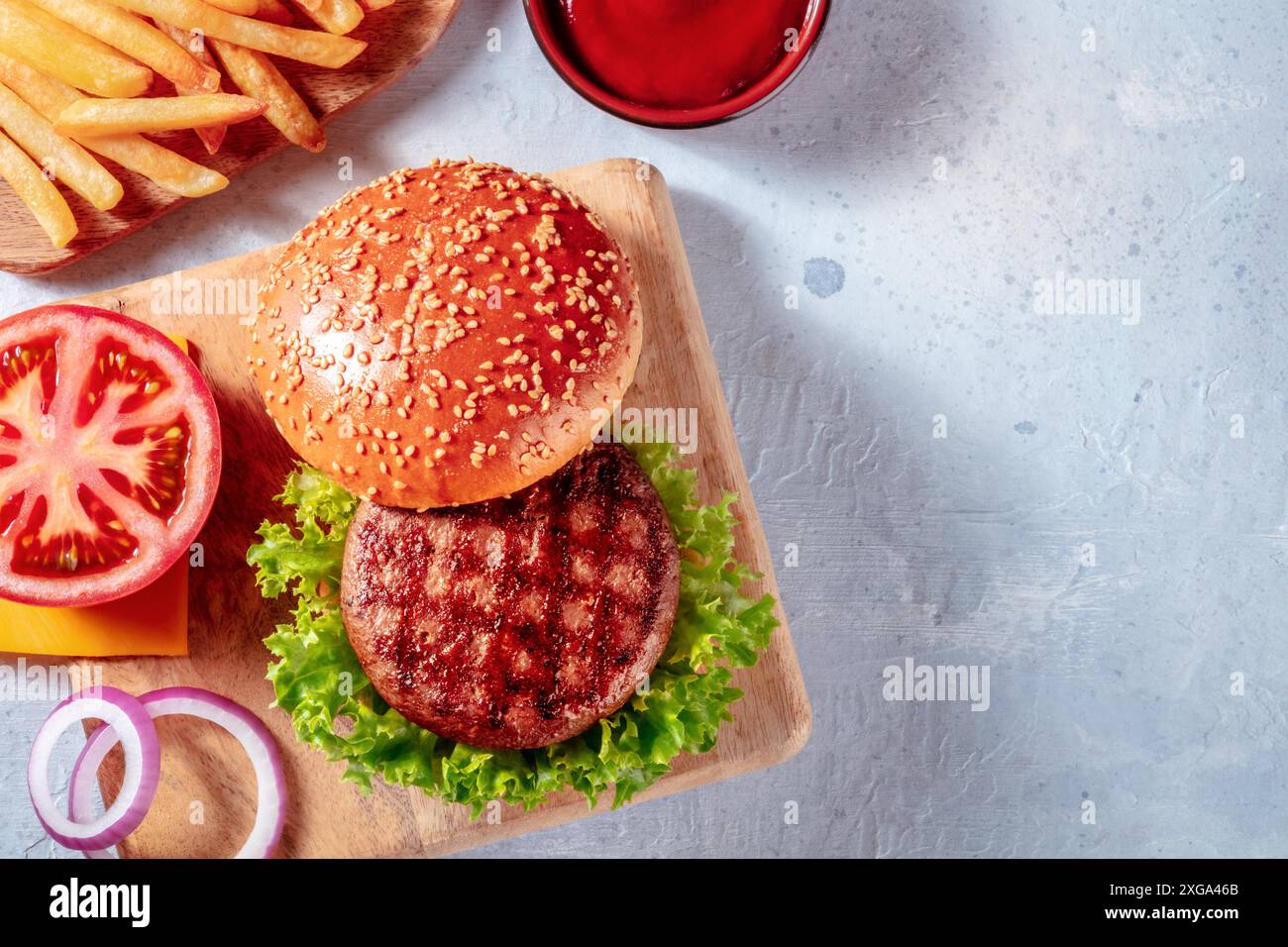 Ingredienti Burger, sparati dall'alto con un posto per il testo. Hamburger di manzo e patatine fritte, con lattuga, pomodoro e cipolla Foto Stock