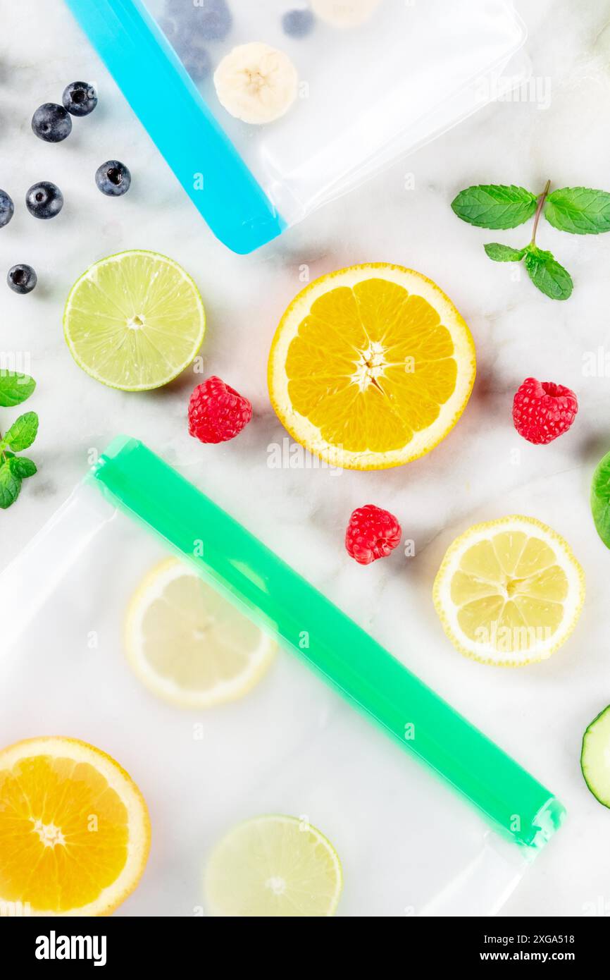 Sacchetti per la conservazione degli alimenti con frutta fresca e verdure, con un colpo superiore su sfondo di marmo bianco. Raccolta estiva in contenitori di ziplock Foto Stock