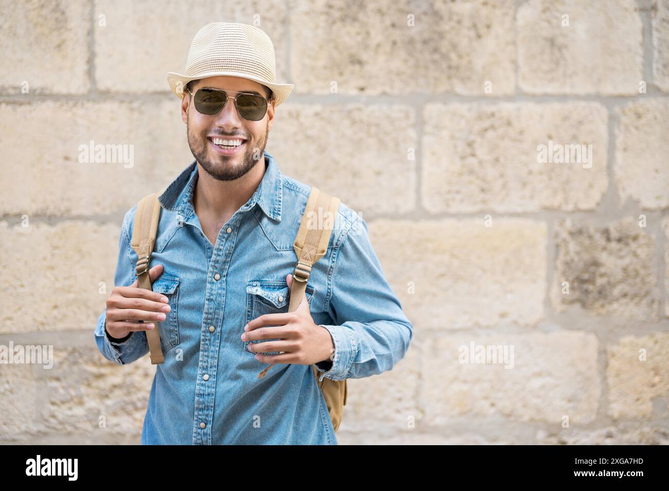 Il viaggiatore elegante ha sopportato l'uomo in posa del cappello guardando la macchina fotografica, il concetto di viaggio e di wanderlust. Foto di alta qualità Foto Stock