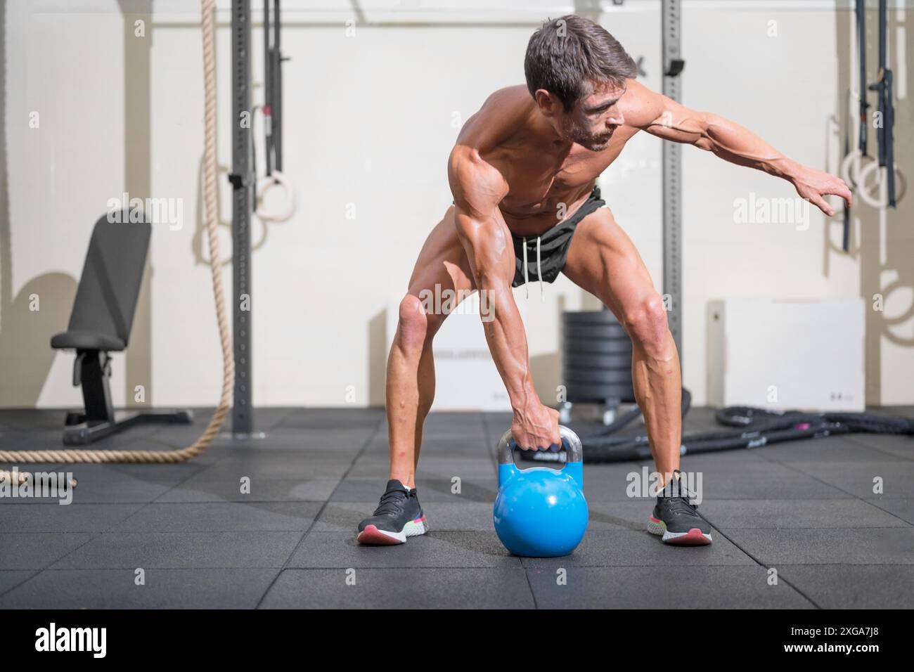 Giovane uomo muscolare allenarsi con kettlebells. Foto di alta qualità Foto Stock