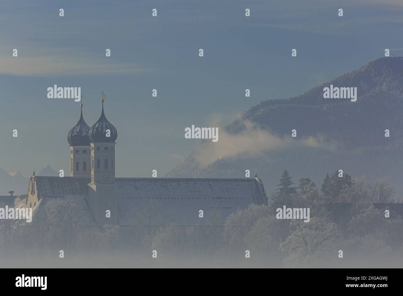 Monastero alla luce del mattino di fronte alle montagne, inverno, monastero Benediktbeuern, Baviera, Germania, Europa Foto Stock