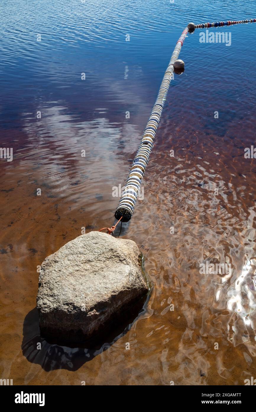 barriera galleggiante sulla spiaggia poco profonda del lago Foto Stock