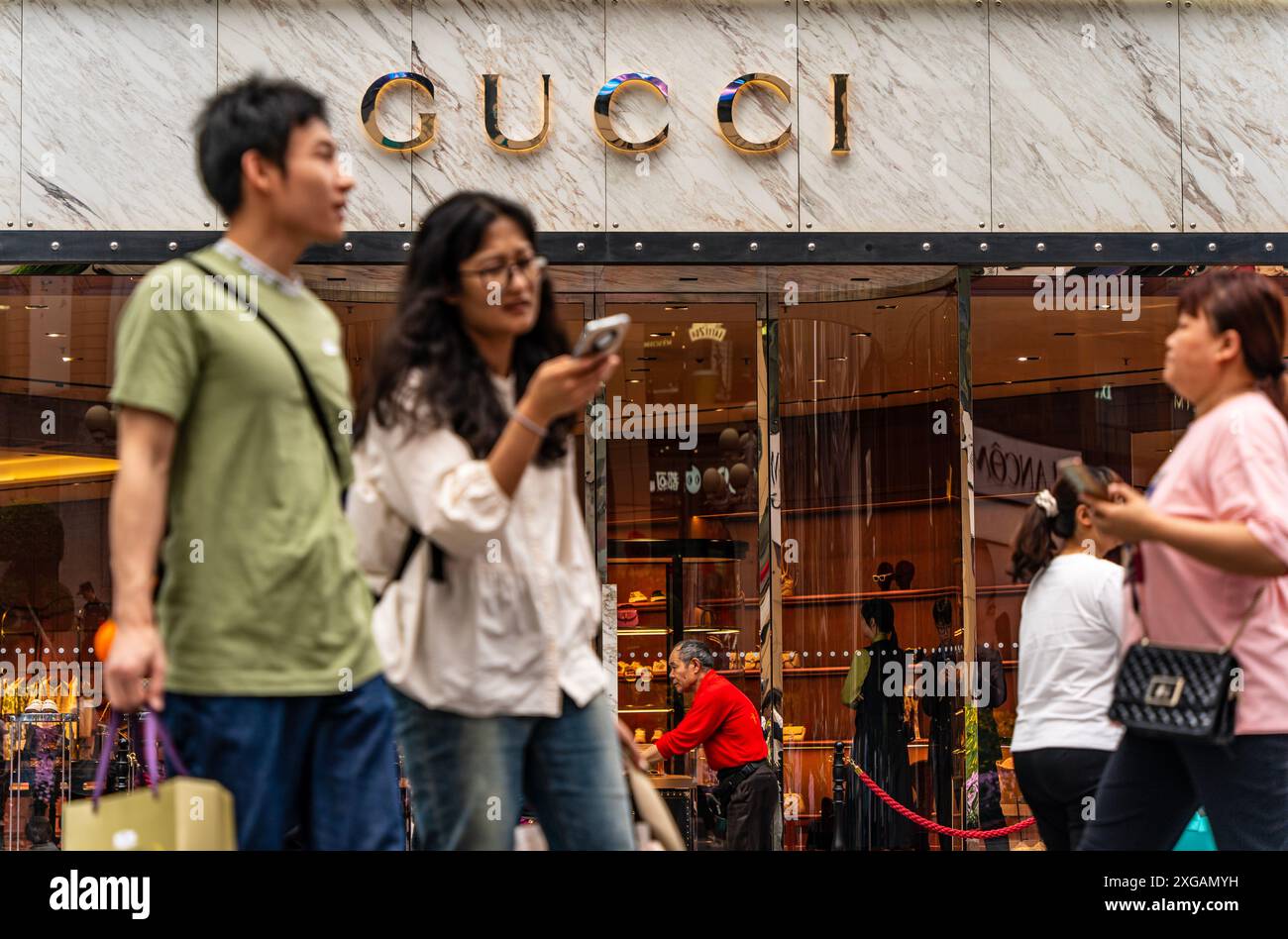 Chongqing, Cina - 8 maggio 2024: Gli acquirenti passano davanti al negozio Gucci di Jiefangbei. Foto Stock