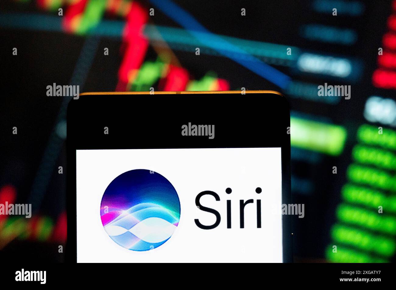 In questa immagine, l'assistente digitale di proprietà di Apple, Siri, logo visualizzato su uno smartphone con un grafico indice di borsa economica sullo sfondo. Foto Stock