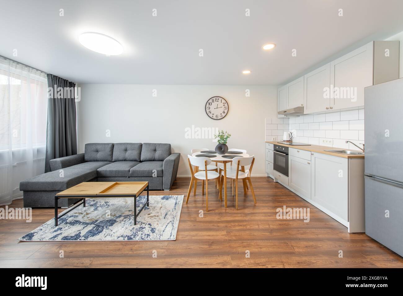 Moderno soggiorno e cucina interna. Lussuoso ed elegante appartamento moderno. Interni aperti, elegante divano, mobili bianchi, design scandinavo. Foto Stock