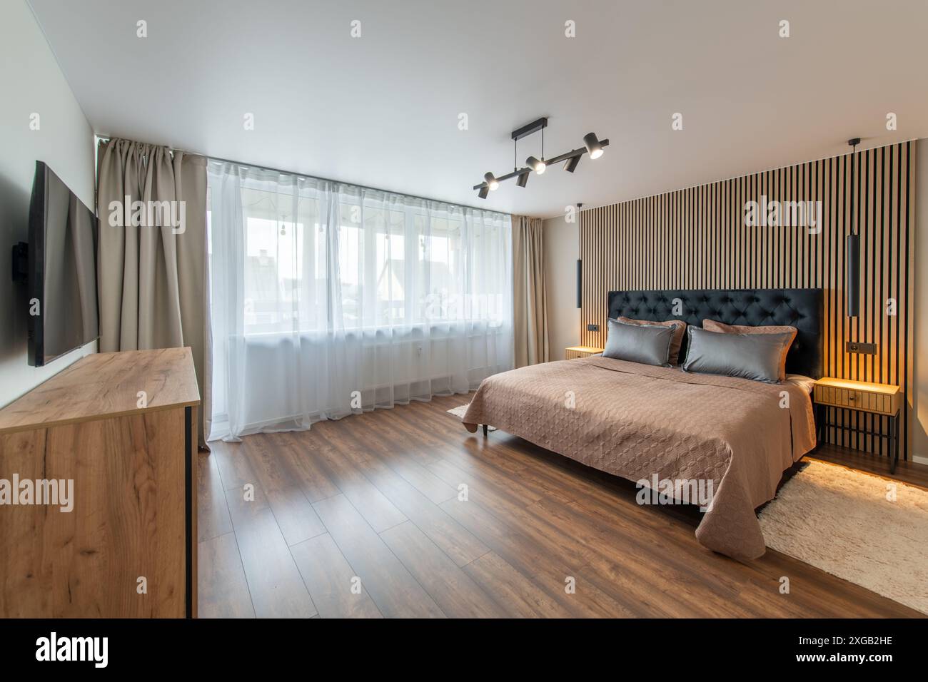 Interni lussuosi della camera da letto principale, casa moderna, splendidi interni, ampia camera da letto. TV sulla parete Foto Stock