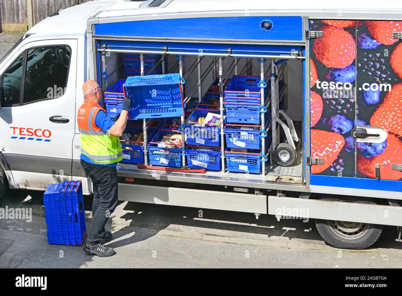 Tesco consegna a domicilio conducente restituisce casse blu vuote al furgone parcheggiato dopo aver completato l'ordine settimanale di acquisto online dei clienti Essex Inghilterra Regno Unito Foto Stock