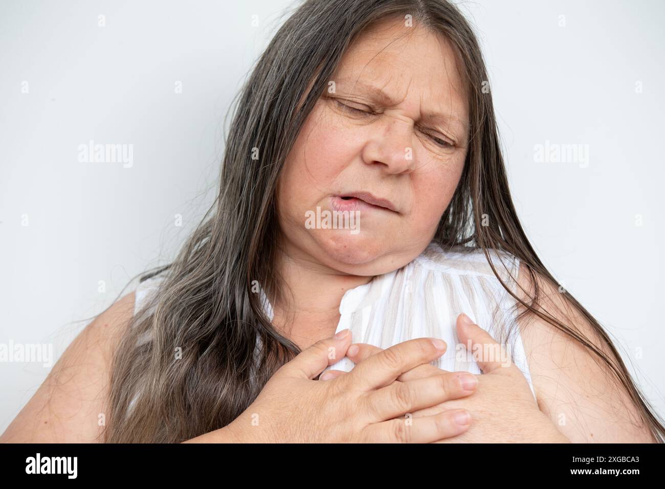 Una donna matura malata tiene al cuore, sperimenta dolore toracico improvviso, ipertensione arteriosa, miocardite o aritmia, cardiopatia ischemica, cercando Foto Stock Una donna matura malata tiene al cuore, sperimenta dolore toracico improvviso, ipertensione arteriosa, miocardite o aritmia, cardiopatia ischemica, cercando Foto Stock