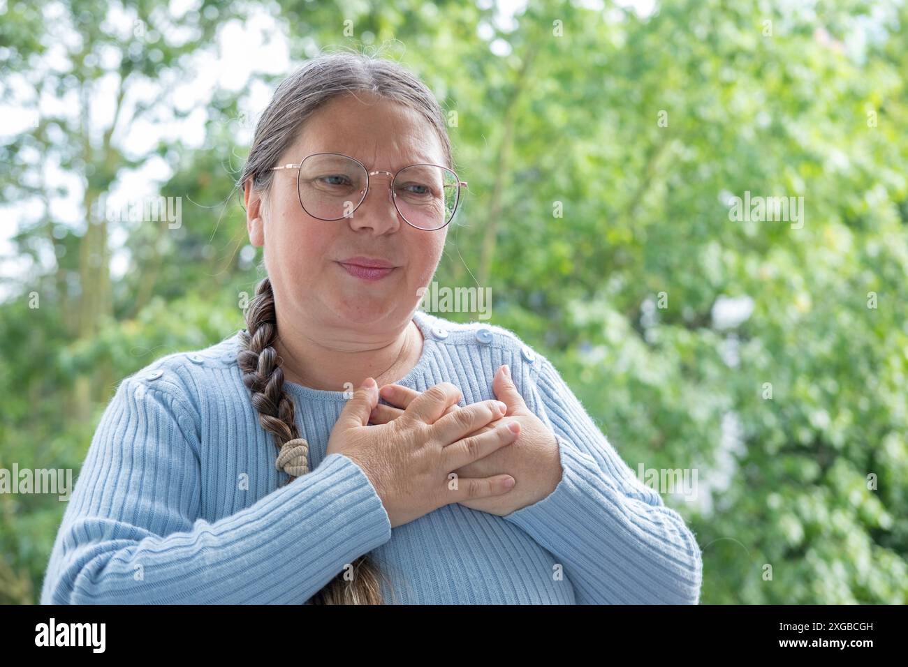 Una donna matura malata tiene al cuore, sperimenta dolore toracico improvviso, ipertensione arteriosa, miocardite o aritmia, cardiopatia ischemica, cercando Foto Stock Una donna matura malata tiene al cuore, sperimenta dolore toracico improvviso, ipertensione arteriosa, miocardite o aritmia, cardiopatia ischemica, cercando Foto Stock