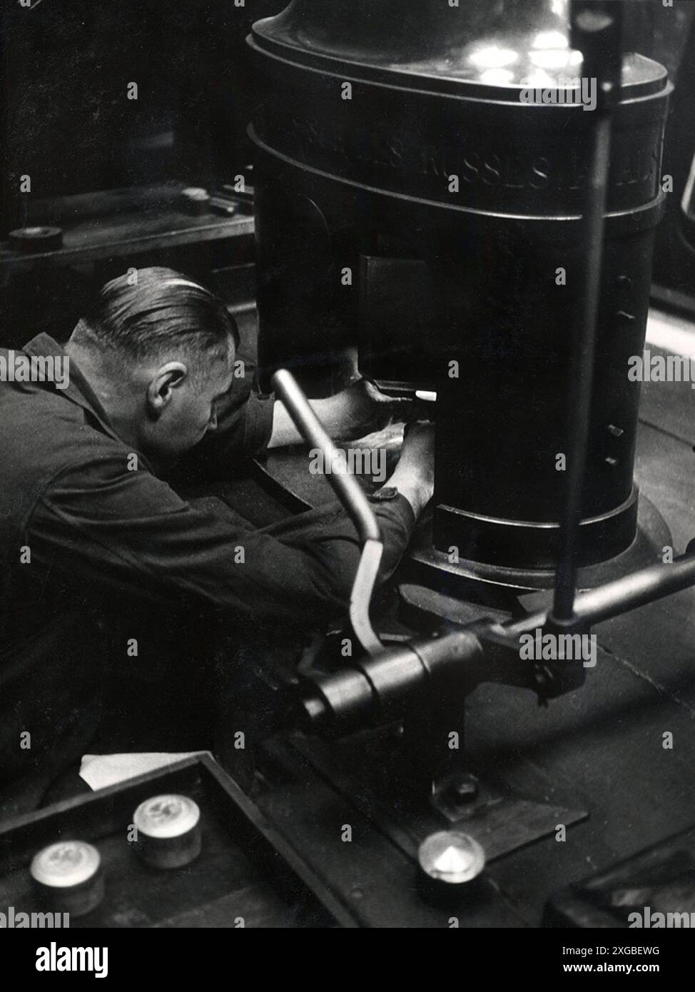 Lavoratore francese che utilizza una macchina di coniatura manuale per la stampa delle monete. Credito anni '1950: Photo12 Foto Stock