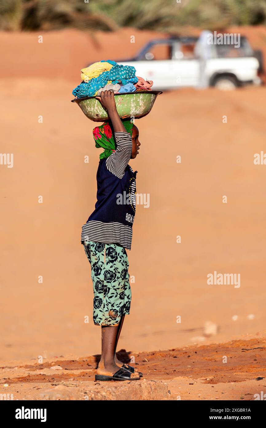 La donna sta lavando i vestiti nel deserto del Sahara in Algeria Foto Stock