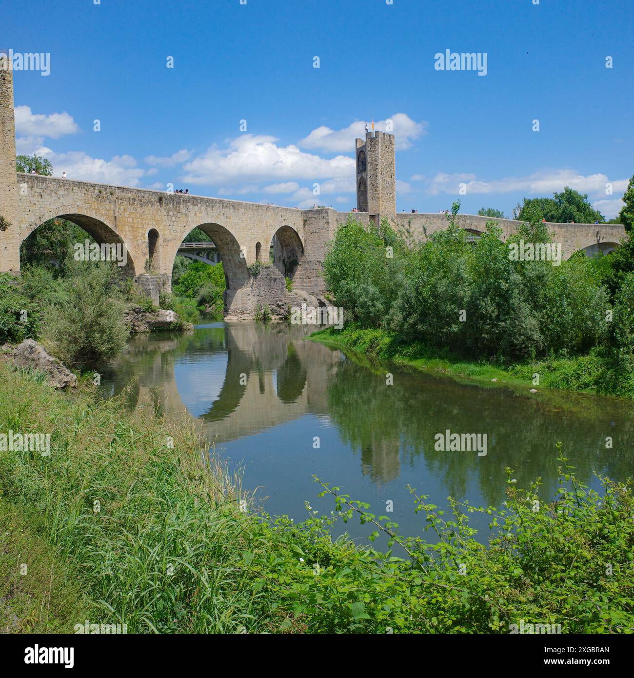 Girona, Spagna - 7 luglio 2024: Riflessioni del ponte medievale Pont Vell sul fiume Fluvia a Besalu, Catalogna Foto Stock
