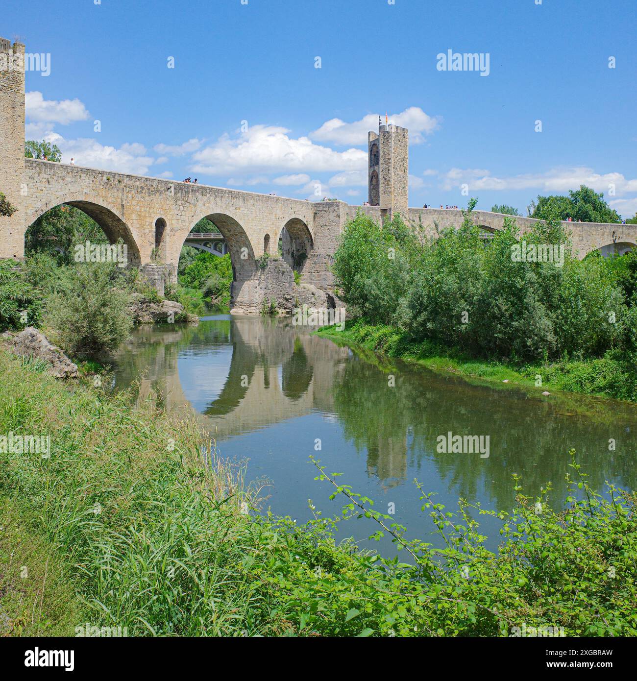 Girona, Spagna - 7 luglio 2024: Riflessioni del ponte medievale Pont Vell sul fiume Fluvia a Besalu, Catalogna Foto Stock