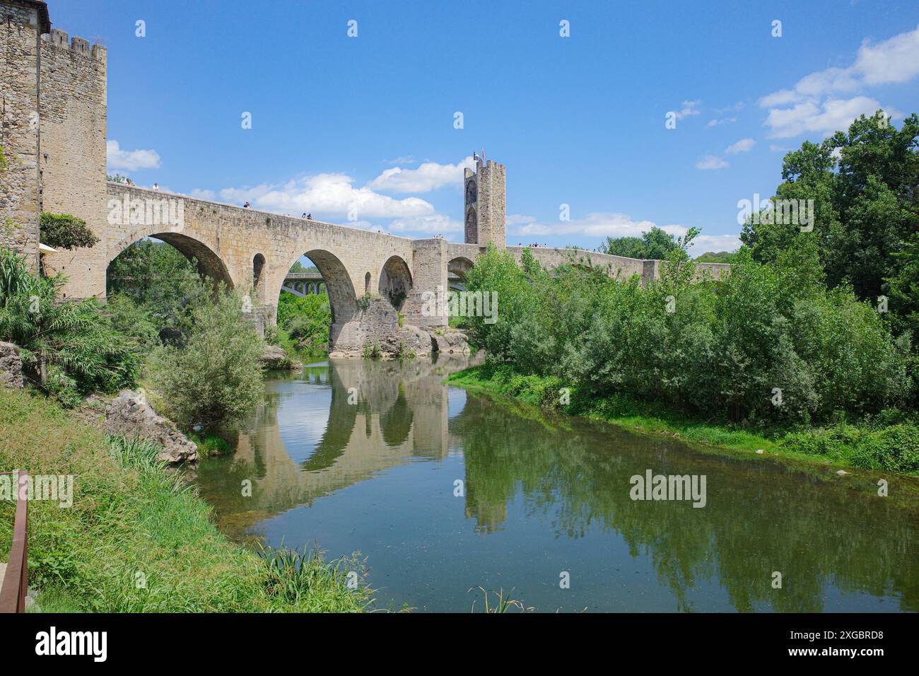 Girona, Spagna - 7 luglio 2024: Riflessioni del ponte medievale Pont Vell sul fiume Fluvia a Besalu, Catalogna Foto Stock