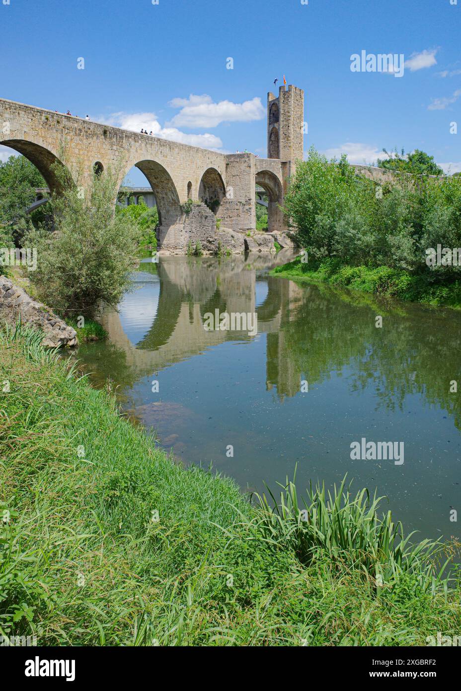 Girona, Spagna - 7 luglio 2024: Riflessioni del ponte medievale Pont Vell sul fiume Fluvia a Besalu, Catalogna Foto Stock