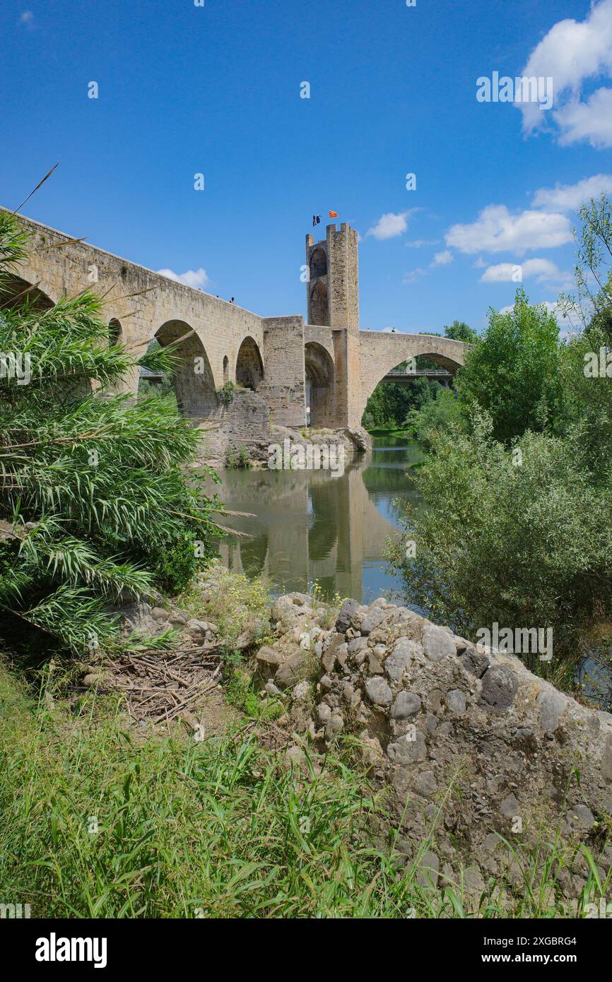 Girona, Spagna - 7 luglio 2024: Riflessioni del ponte medievale Pont Vell sul fiume Fluvia a Besalu, Catalogna Foto Stock