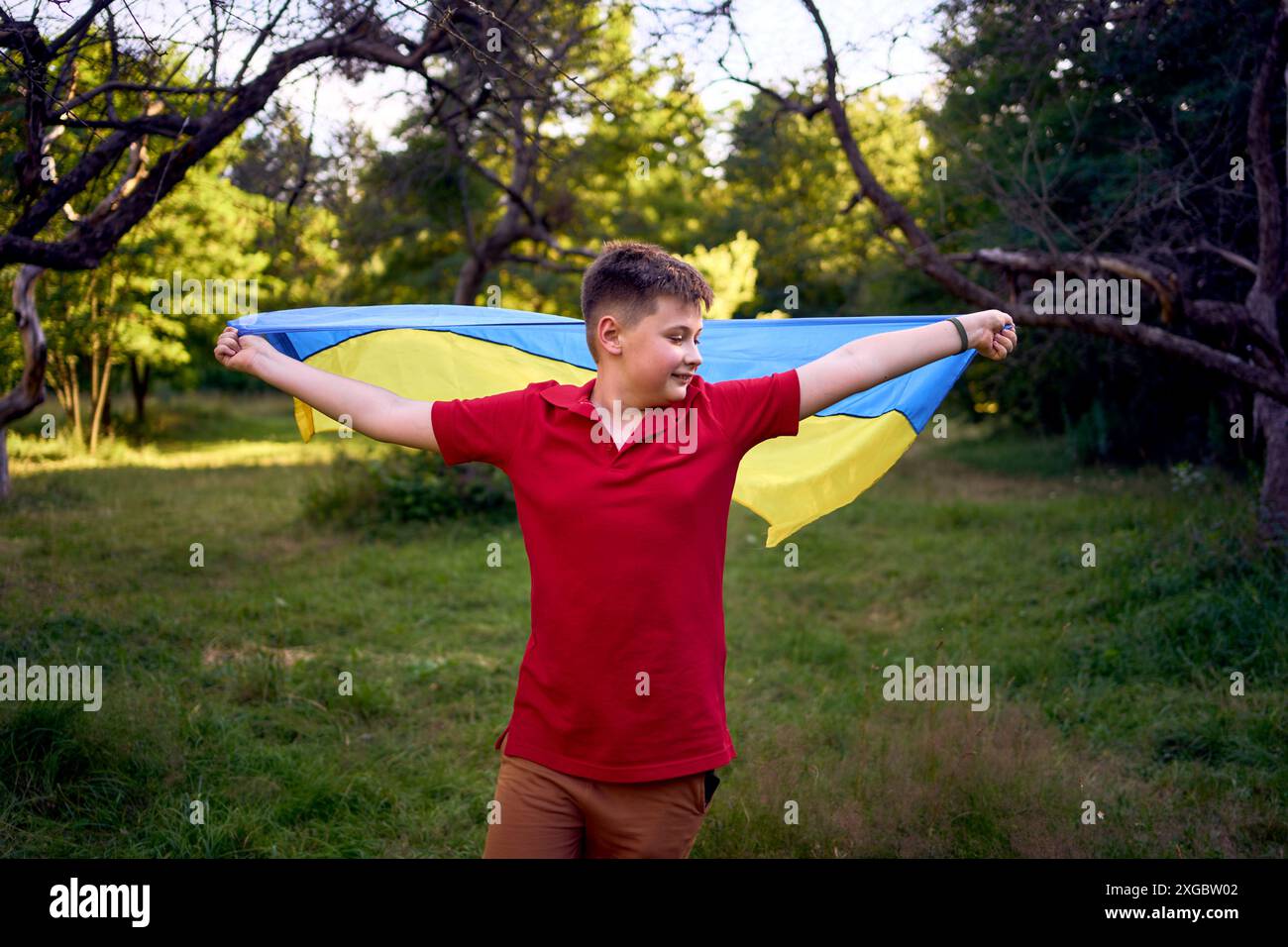 Preadolescente corre nel parco con la bandiera dell'Ucraina Foto Stock