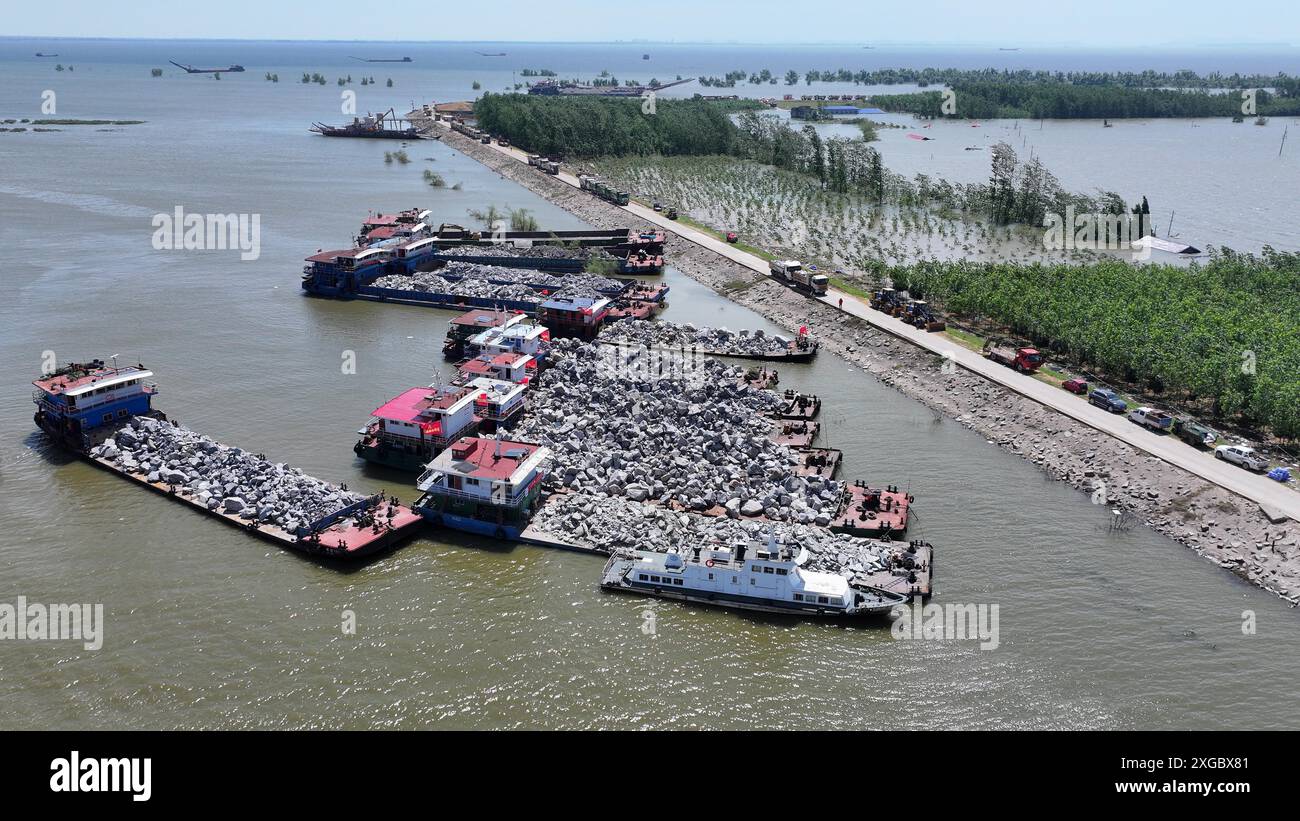 Huarong, la provincia cinese di Hunan. 8 luglio 2024. Una foto aerea mostra i soccorritori che lavorano per bloccare la breccia di dighe nel lago Dongting nella contea di Huarong, nella provincia di Hunan della Cina centrale, 8 luglio 2024. A partire da lunedì pomeriggio, 180,5 metri della breccia di 226 metri nella diga erano stati sigillati, secondo il quartier generale del controllo delle inondazioni e della siccità di Yueyang. Crediti: Chen Zhenhai/Xinhua/Alamy Live News Foto Stock