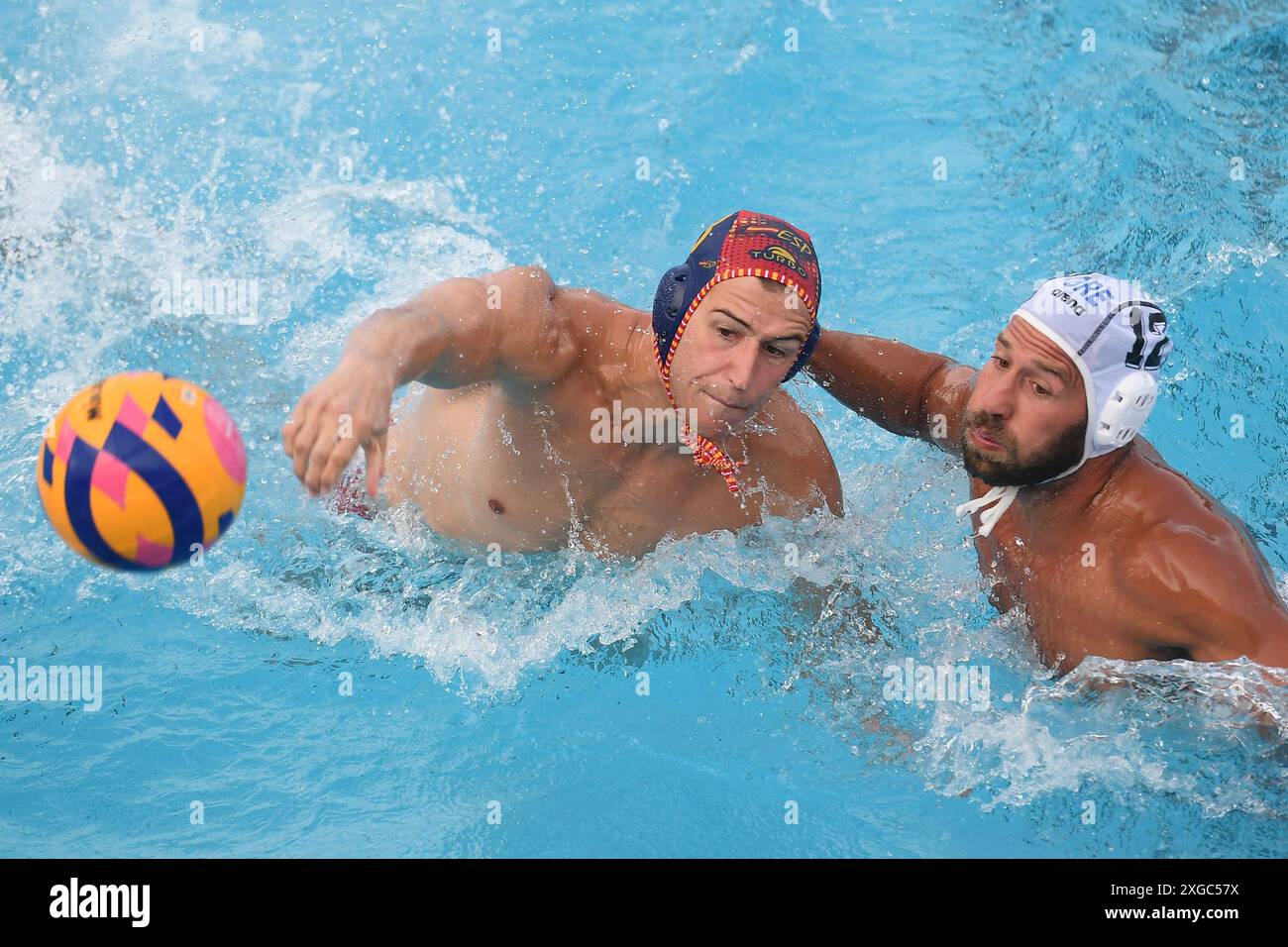 Alvaro Granados Ortega di Spagna e Angelos Vlachopoulos di Grecia durante la partita maschile di pallanuoto di Coppa di Sardegna tra Grecia (berretti bianchi) e Spagna (berretti blu) alla piscina comunale di Alghero (Italia), 6 luglio 2024. Foto Stock